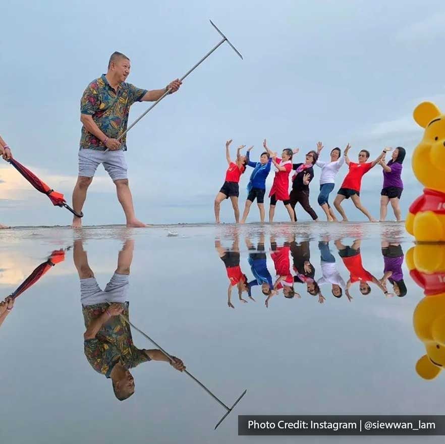 A group of people were striking creative poses and taking a picture at Bagan Datuk Sky Mirror - Lexis Suites Penang