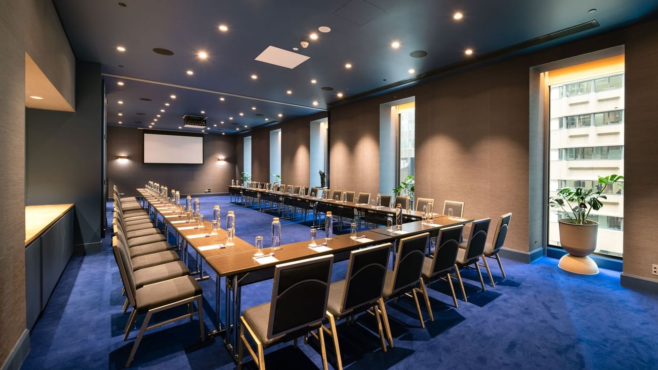 Edwin Flack room boardroom with U-shaped table configuration, blue carpet and projection screen