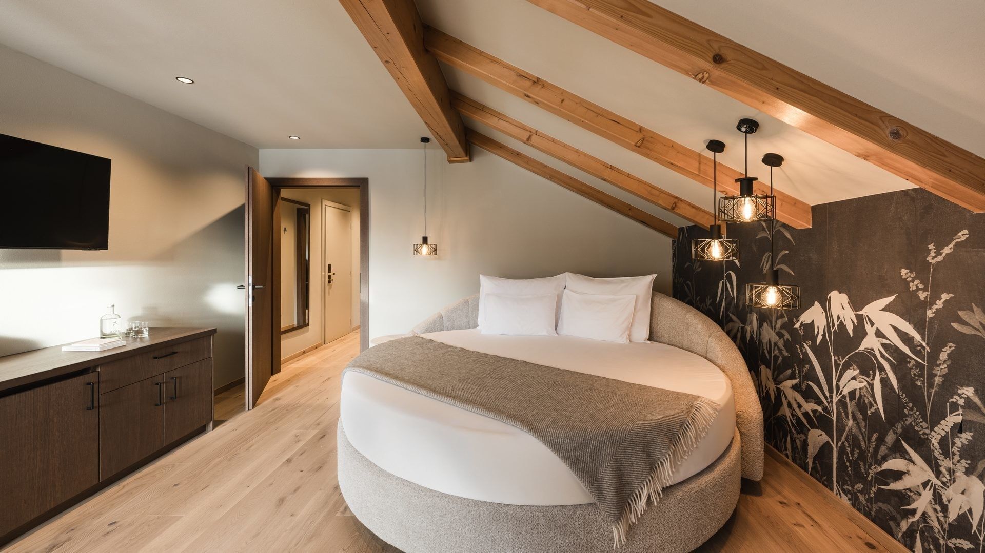 Gemütliche Premium Suite Bergliebe mit rundem Bett und Holzdetails im Falkensteiner Hotel Antholz.