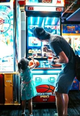 A father and daughter playing Basketball Pro at an Orlando arcade.