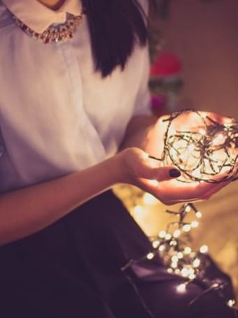 Girl with Christmas lights at The Sebel Quay West Suites Sydney