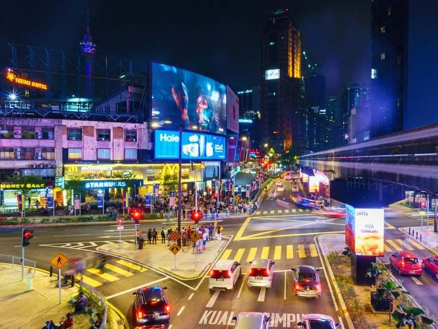 Busy streets in KLCC with colorful lights at night near Imperial Lexis KL Luxury Hotel