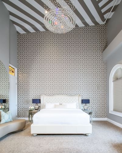 Chandelier, king bed with padded headboard & wallpaper in Presidential Suite in Retro Suites Hotel