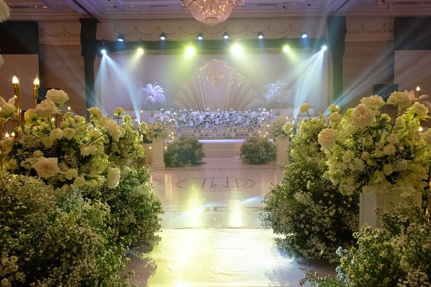 A lavish wedding stage adorned with white flowers, twinkling lights, and elegant decor at Park Hyatt Saigon