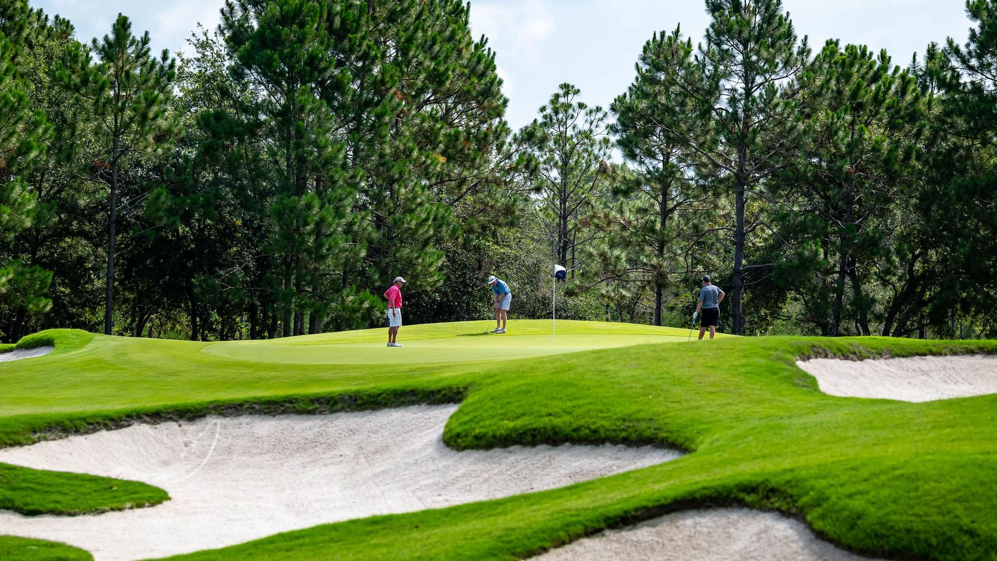 Landscape view of people playing in a golf course at Camp Creek Inn
