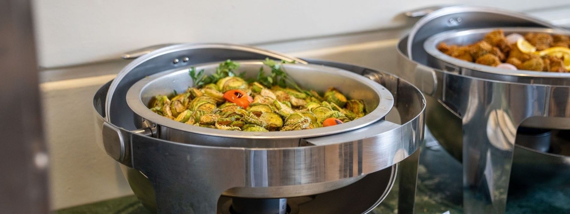 Sliced sautéed zucchini served in a round stainless steel buffet  in Al Firdous Restaurant at Saja Warwick Madinah