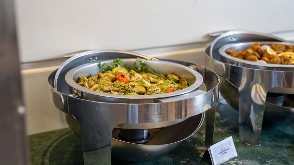 Sliced sautéed zucchini served in a round stainless steel buffet  in Al Firdous Restaurant at Saja Warwick Madinah