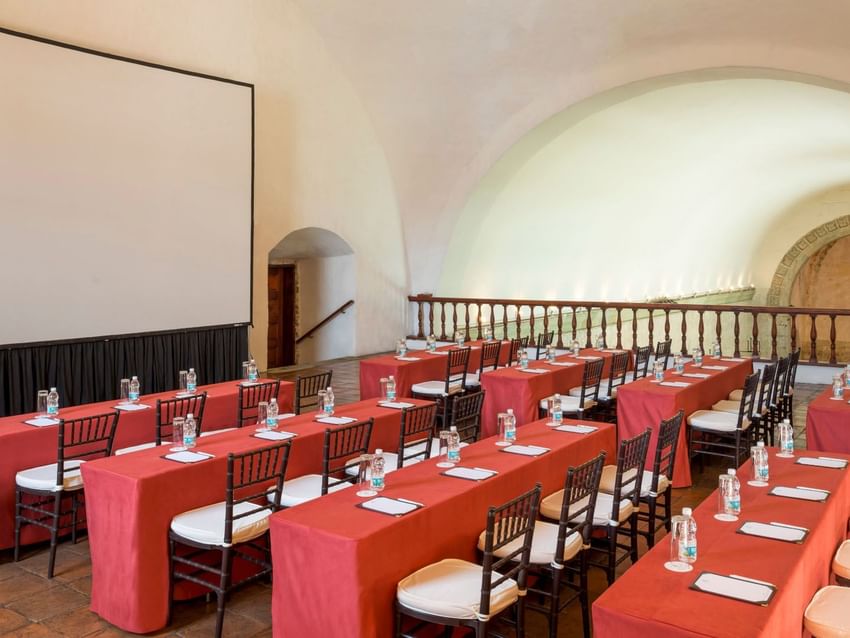 Classroom set-up with water bottles and a projector screen in Alto Coro Salon at Quinta Real Oaxaca