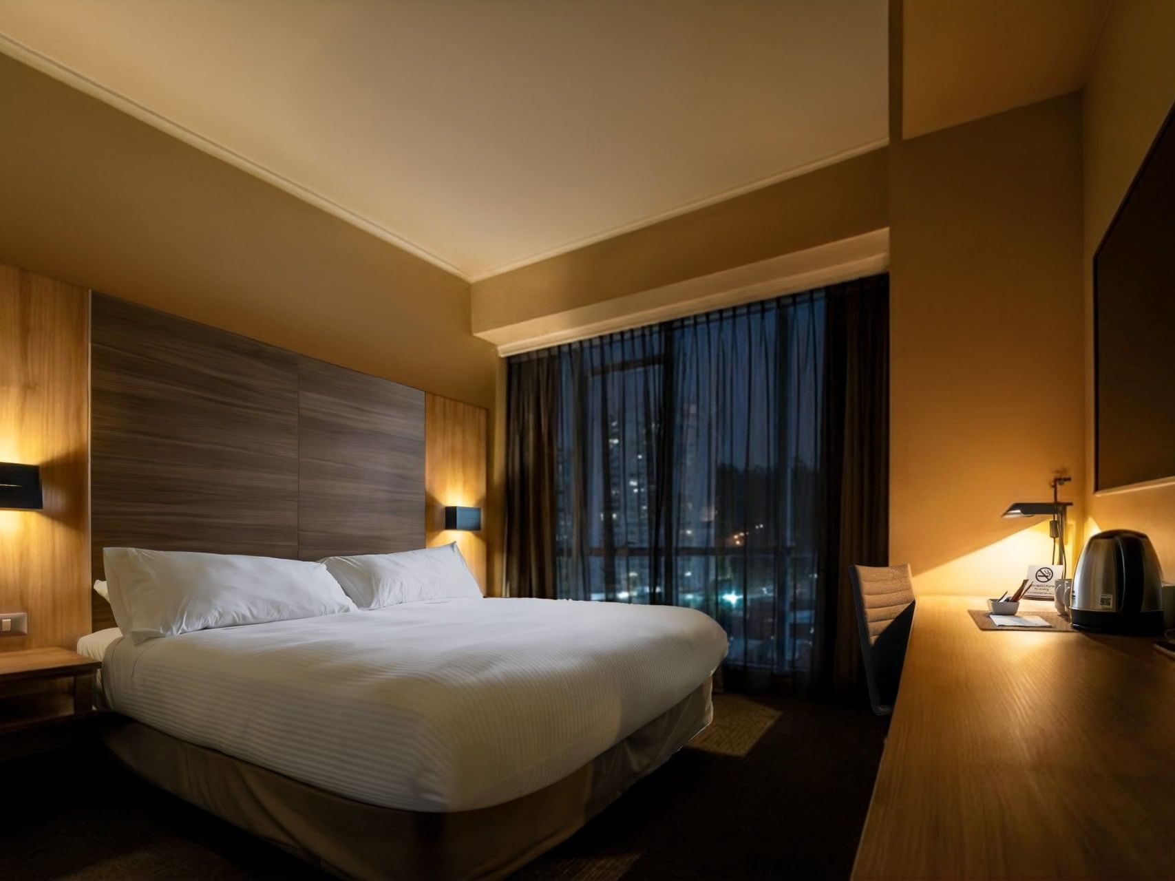 Una lujosa habitación de hotel con una cama grande y una decoración moderna en el hotel HCC Costanera Concepción.
