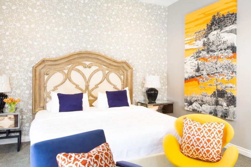 Bed, armchairs & a wall art in King Premiere Pop at Retro Hotel
