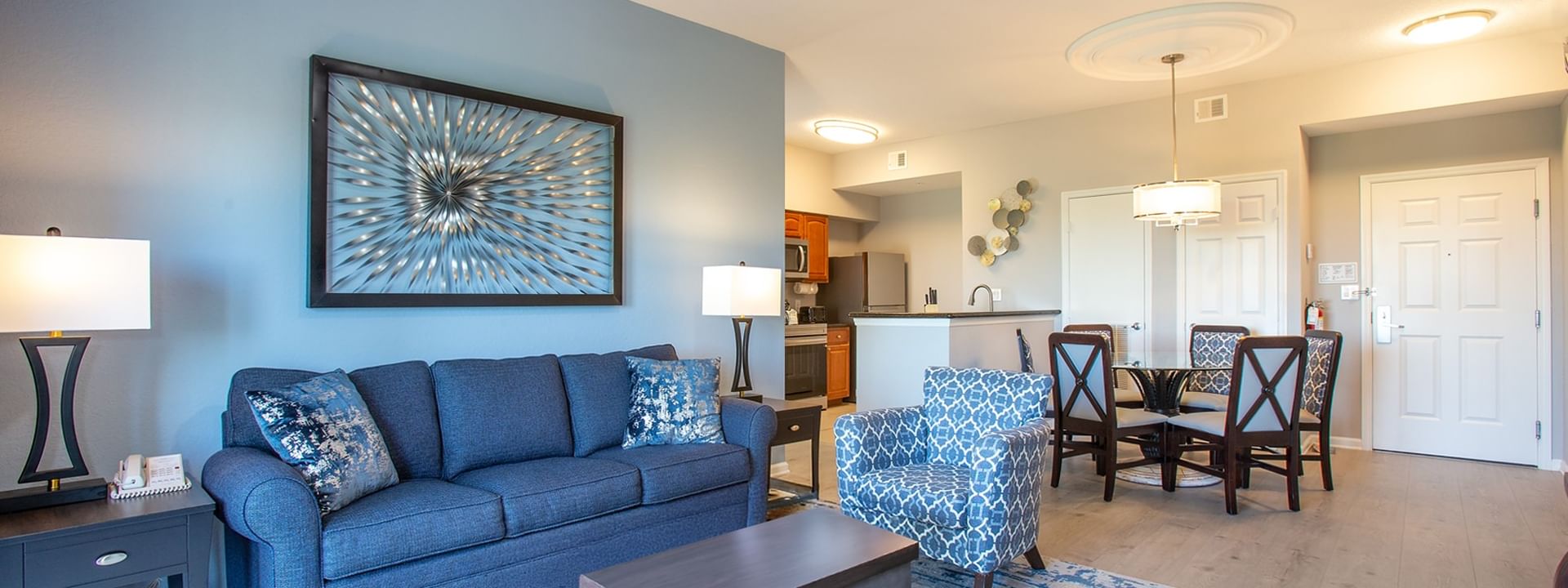 A wide view of a suite's living area, kitchenette, and dining space