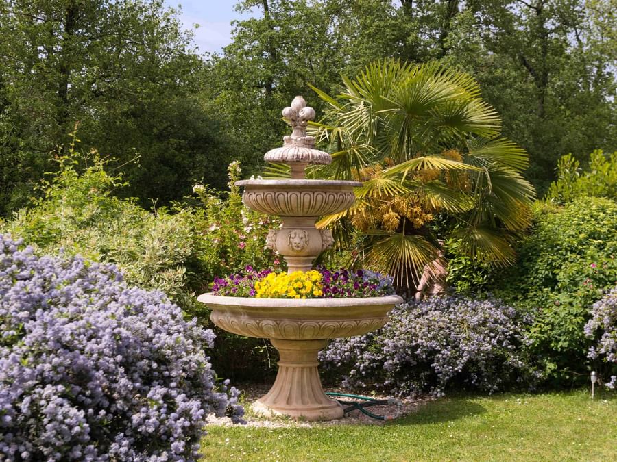 View of a Garden with Flowers & a fountain at Hotel Pic Epeiche