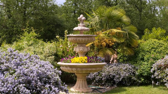 View of a Garden with Flowers & a fountain at Hotel Pic Epeiche