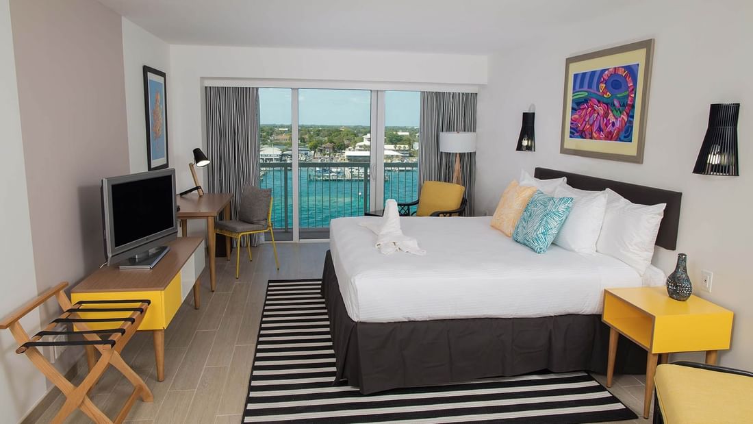 King-size bed, work desk & a TV in Harbor Deluxe Balcony at Warwick Paradise Island Bahamas