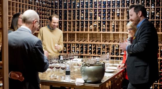 5 people tasting wine in the Wine Cellar at Stein Eriksen Lodge