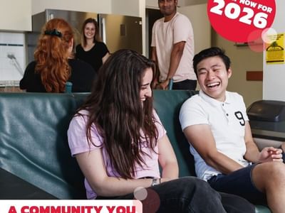 A group of young people socializing in a kitchen, with a slogan 