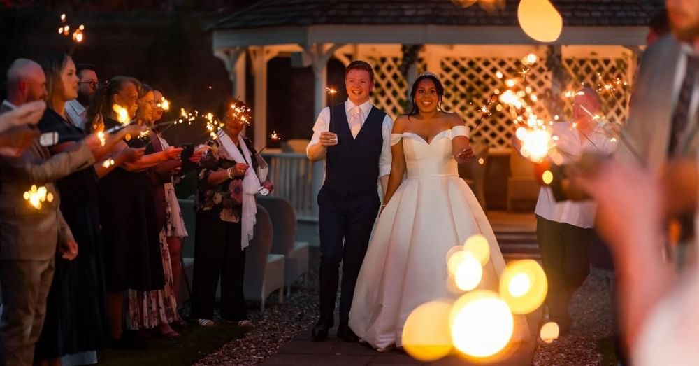 Newlyweds celebrating with sparklers beside the Wedding Pavilion