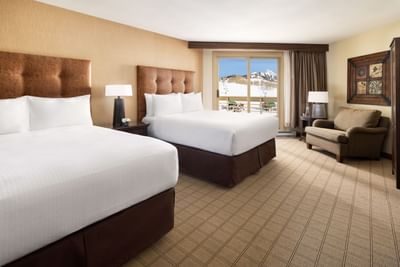 Two beds, couch, and large window with mountain view at Elevation Resort and Spa