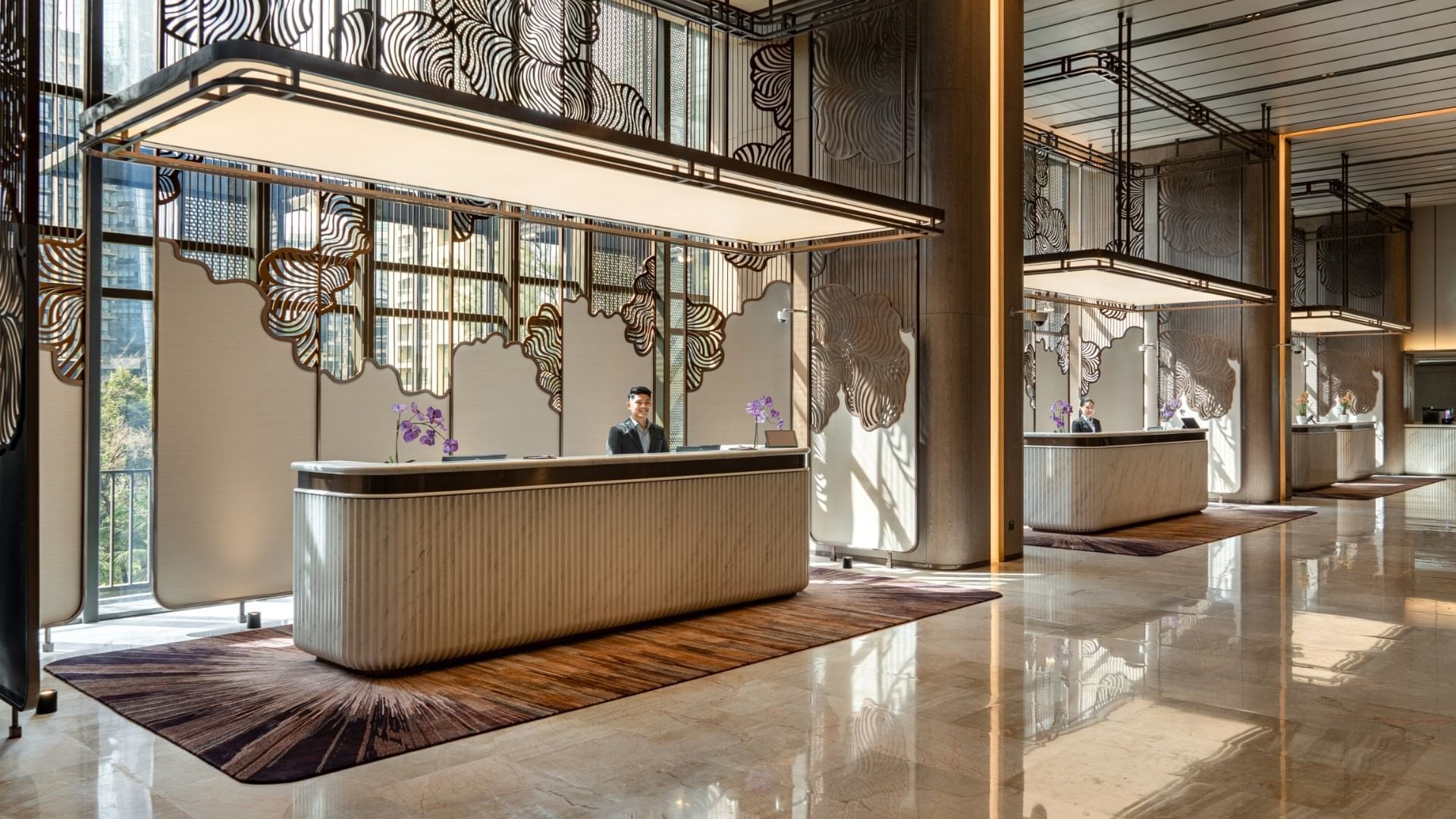 The receptionist in the front desk with a spacious lobby area at Imperial Lexis Kuala Lumpur