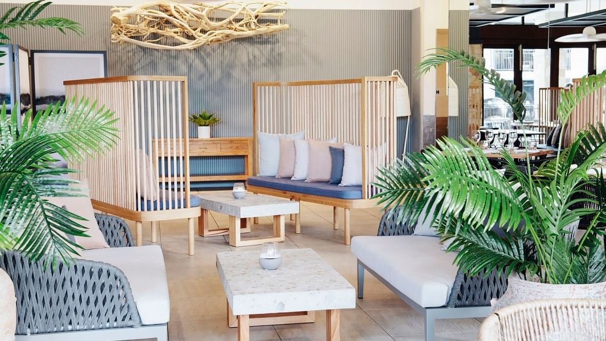 Aluco Restaurant with decorative plants, tables & chairs at Pullman Port Douglas