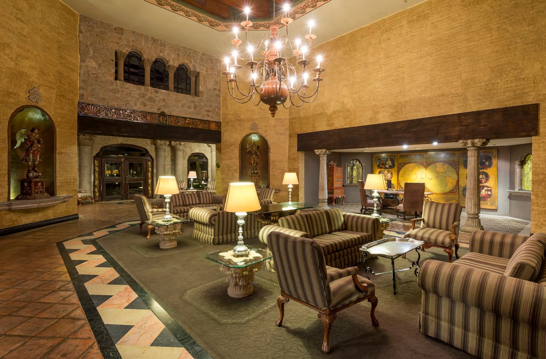 Los Murales Restaurant and Bar featuring striped sofas and a large chandelier at Quinta Real Aguascalientes