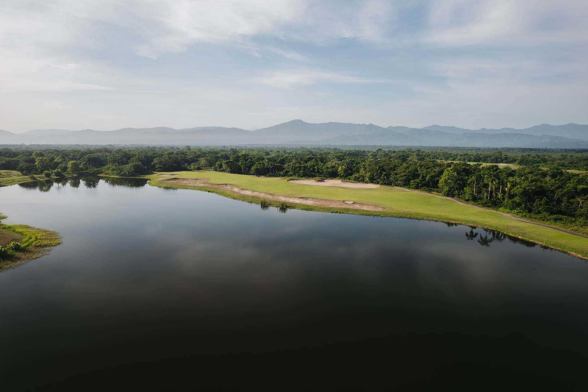 Aerial view of a narrow river through lush greenery near Indura Beach & Golf Resort