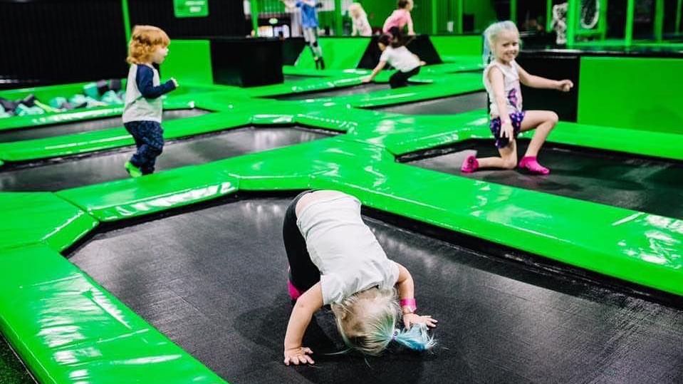 Kids joyfully jump and play on interconnected trampolines at Flip Out Mandurah near The Sebel Mandurah indoor park