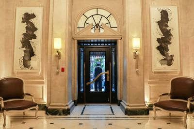 Elegant lobby with two armchairs & paintings at The Eliot Hotel