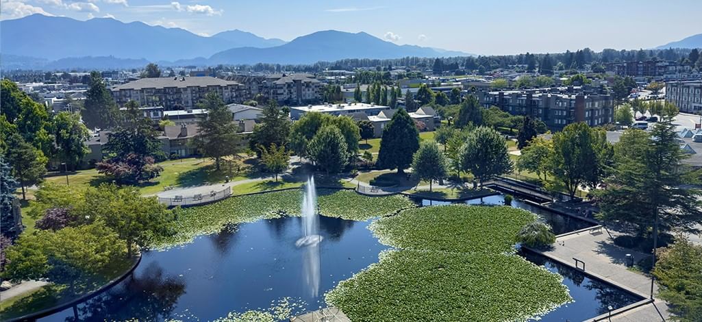 View of a beautiful park with fountain and mountains in the background.