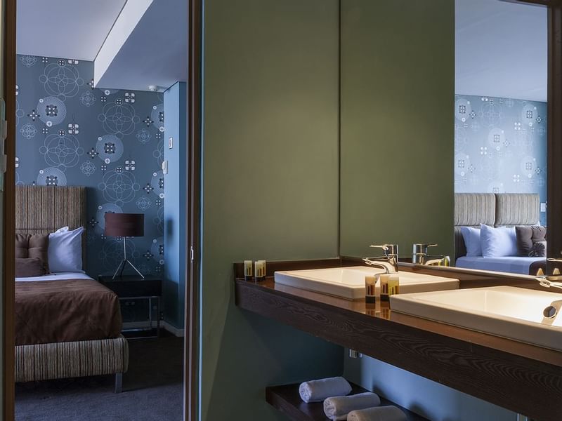 Bathroom vanity & bedroom in the Master Suite at Gamma Hotels