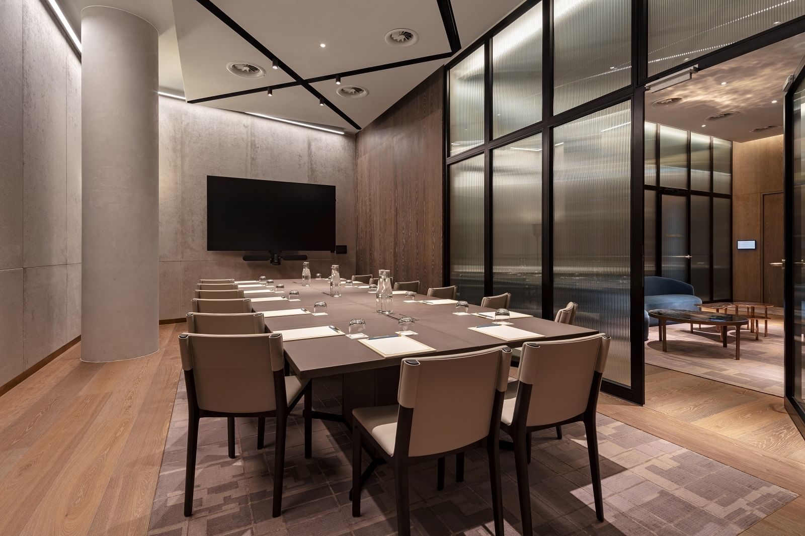 Hayward Gallery meeting room at The Londoner Hotel, with chairs arranged neatly facing a TV