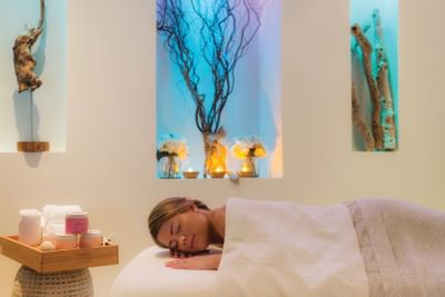 A woman lying on a spa bed at Windsong Resort On The Reef