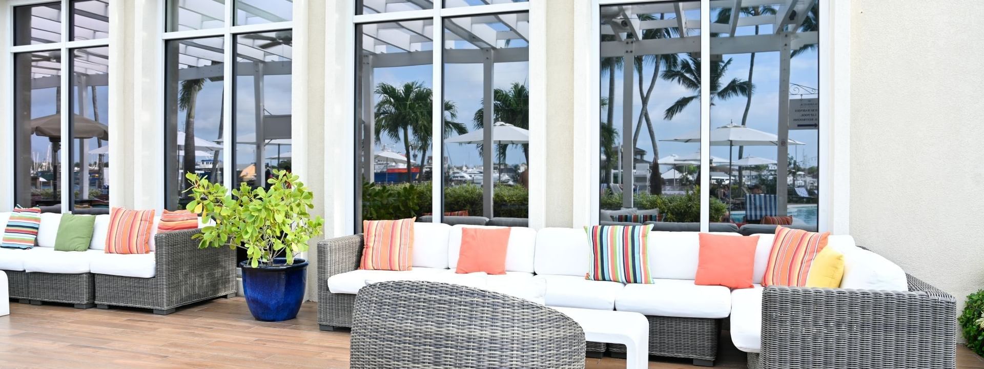 Verandah with White sofas by a grey chair under a white pergola at Warwick Paradise Island Bahamas