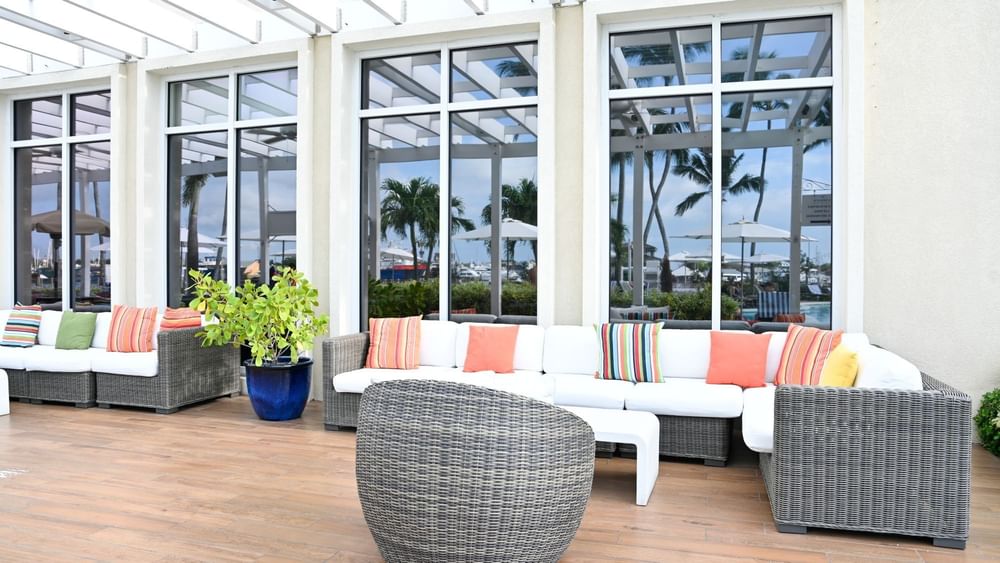 Verandah with White sofas by a grey chair under a white pergola at Warwick Paradise Island Bahamas