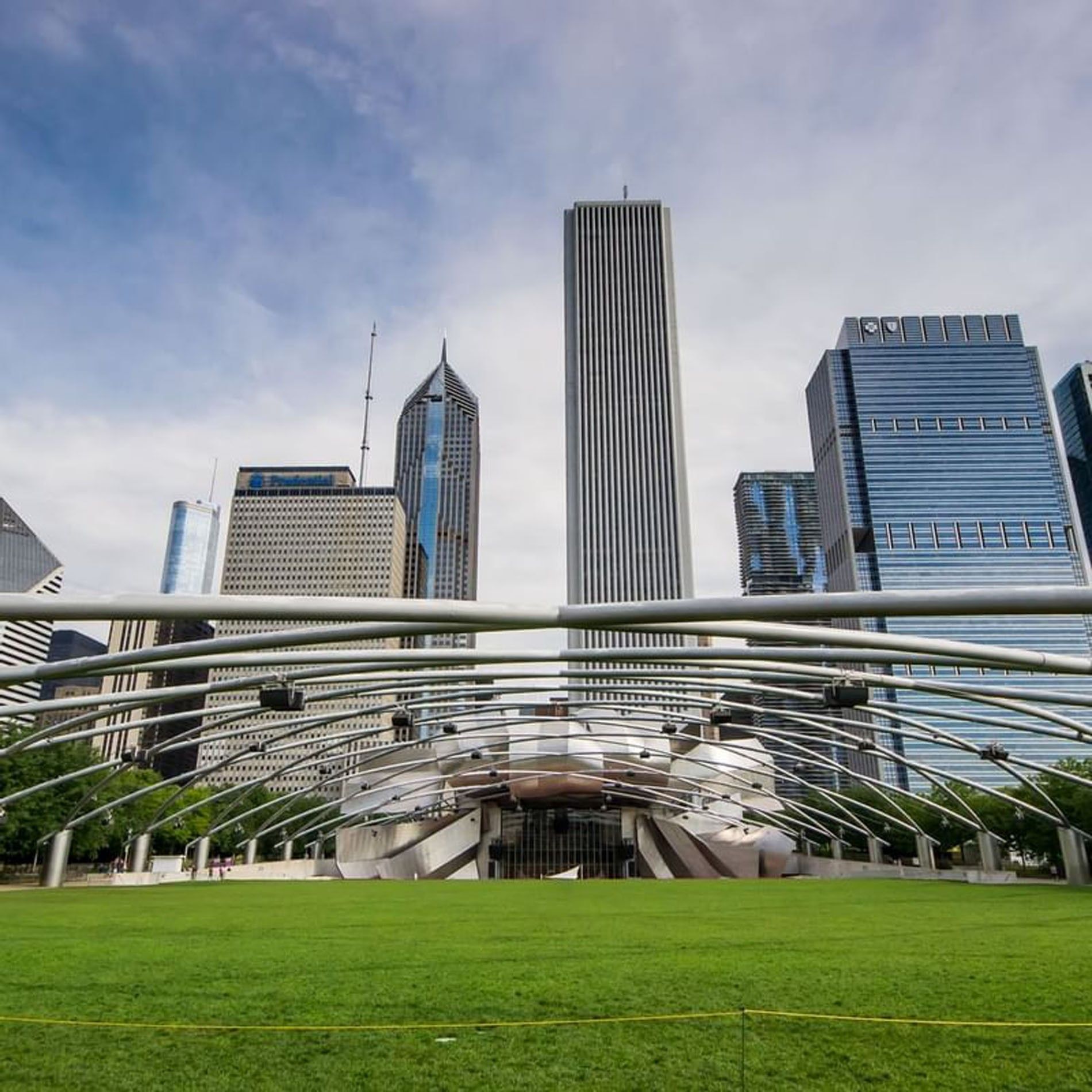 Skyscrapers with green lawn and metal canopy structure in the foreground at Warwick Allerton Chicago Redesign