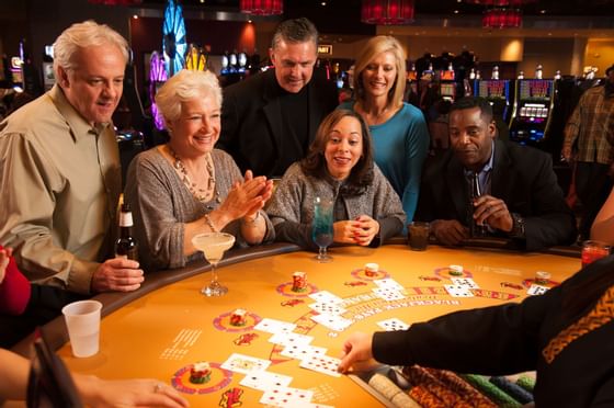 A group playing poker in a casino near Pearl River Resorts