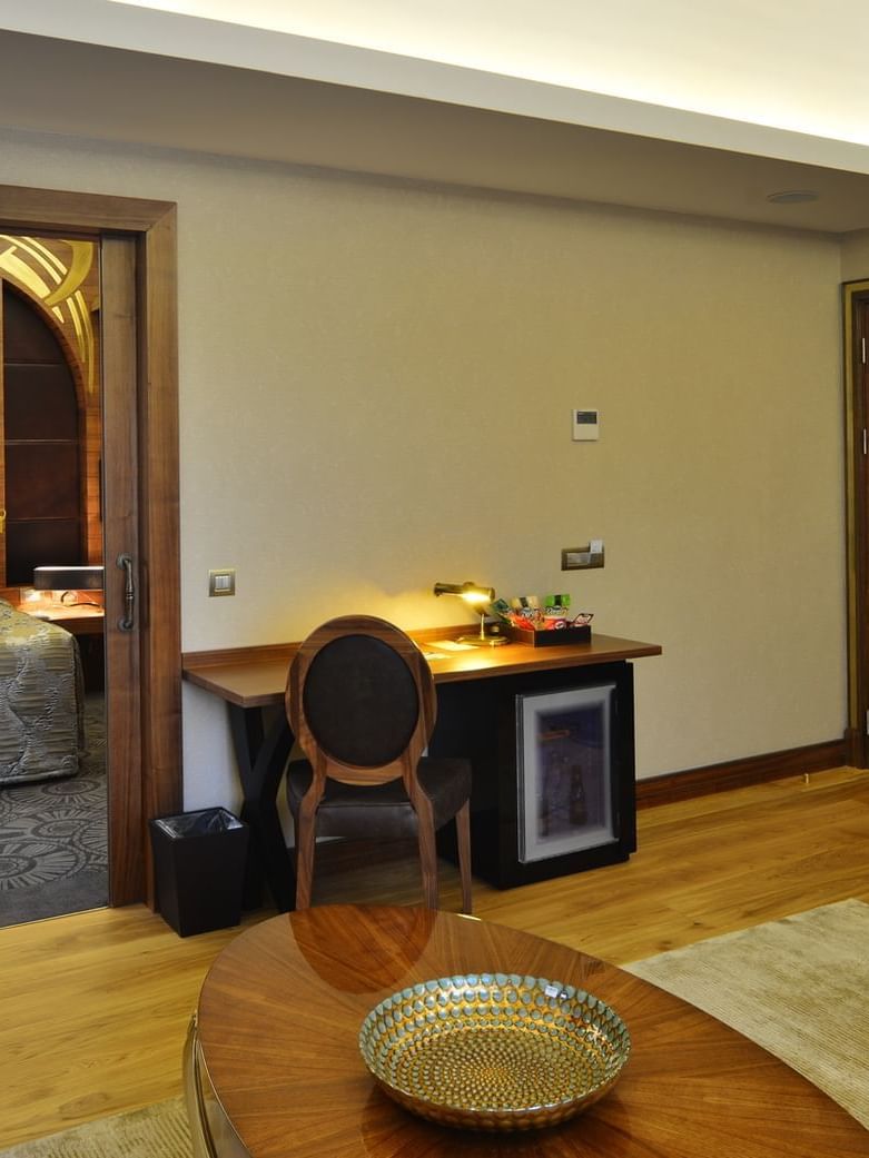 Oval table on a rug by a desk and fridge unit in Warwick Suite with Terrace featuring at Warwick Ankara