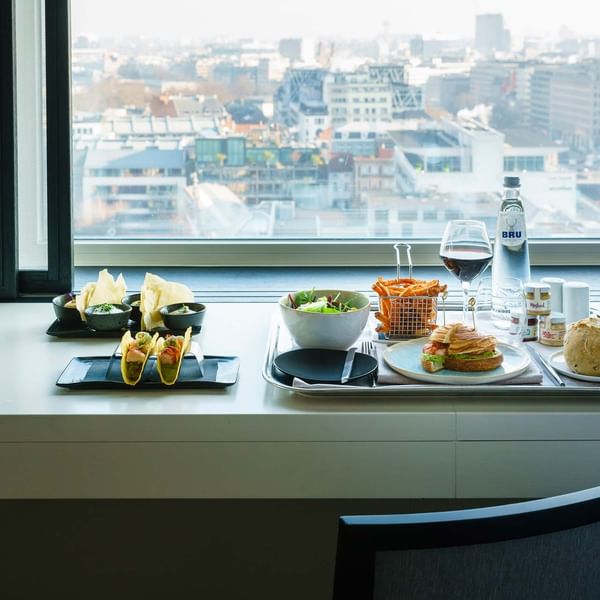 A full meal served by a window in a room at The Hotel Brussels