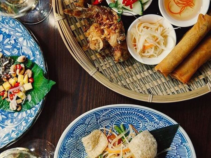 Diverse Thai appetizers served in woven baskets by blue and white patterned plates at Warwick Le Crystal Montreal