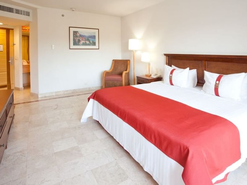 King bed & ancient chair in the Superior Room at Gamma Hotels