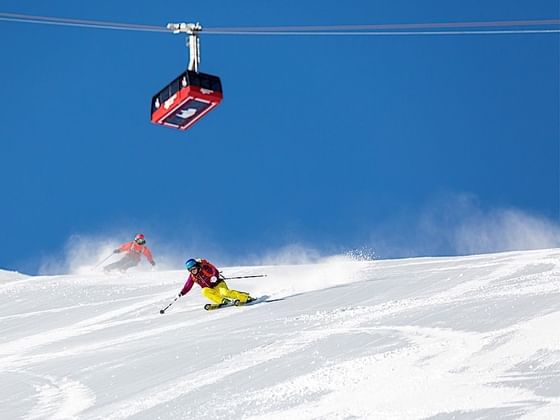 Two men skiing down the hills near Hotel Jackson