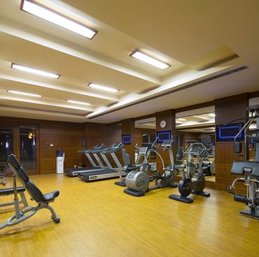 Gym equipment lined up in wooden floored Fitness Center at Titanic City Taksim