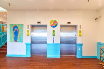 Brightly colored lobby with two elevators & vibrant wall arts at Park Place Hotel Ocean City
