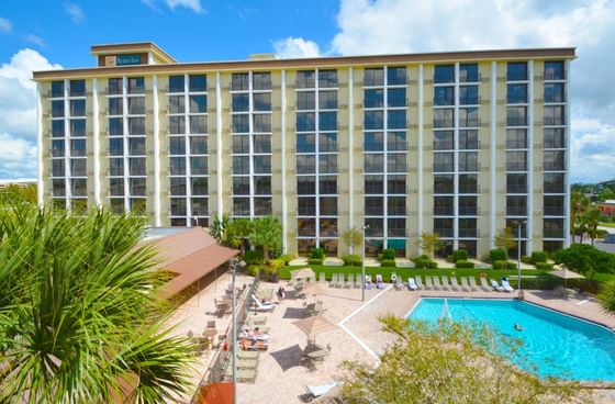 Exterior view of outdoor pool area & hotel building at Rosen Inn Hotels and Resorts