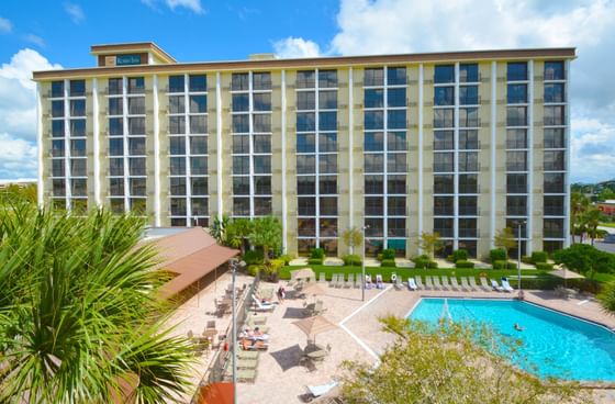 Aerial view of an outdoor swimming pool surrounded by lounge chairs in front of the Rosen Inn Closest to Universal