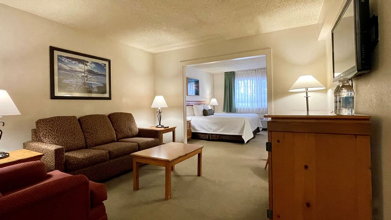 Sofa and coffee table and a bed in separate room with a window