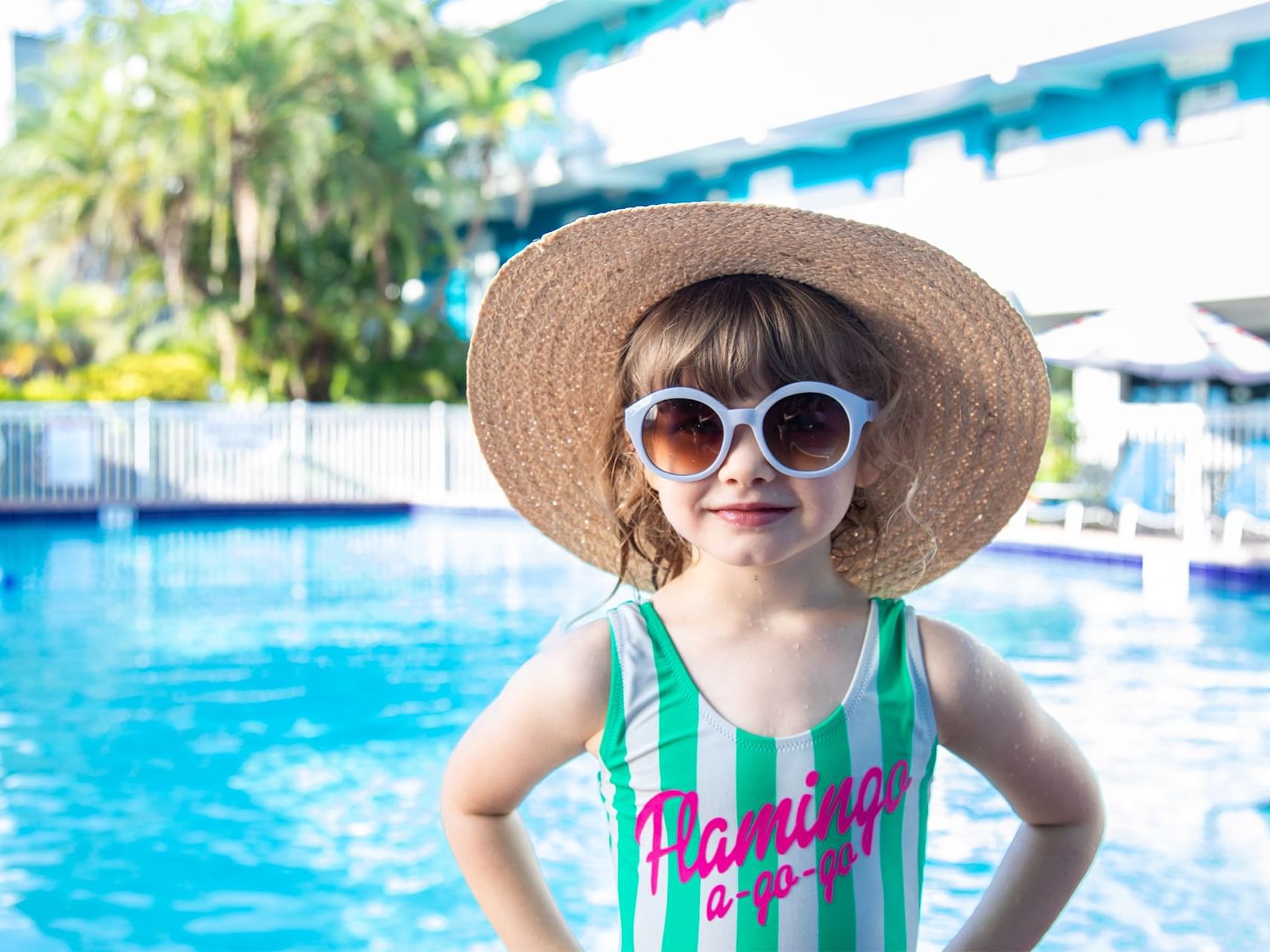 Girl posing with shades & a hat by the pool at Bilmar Beach Resort