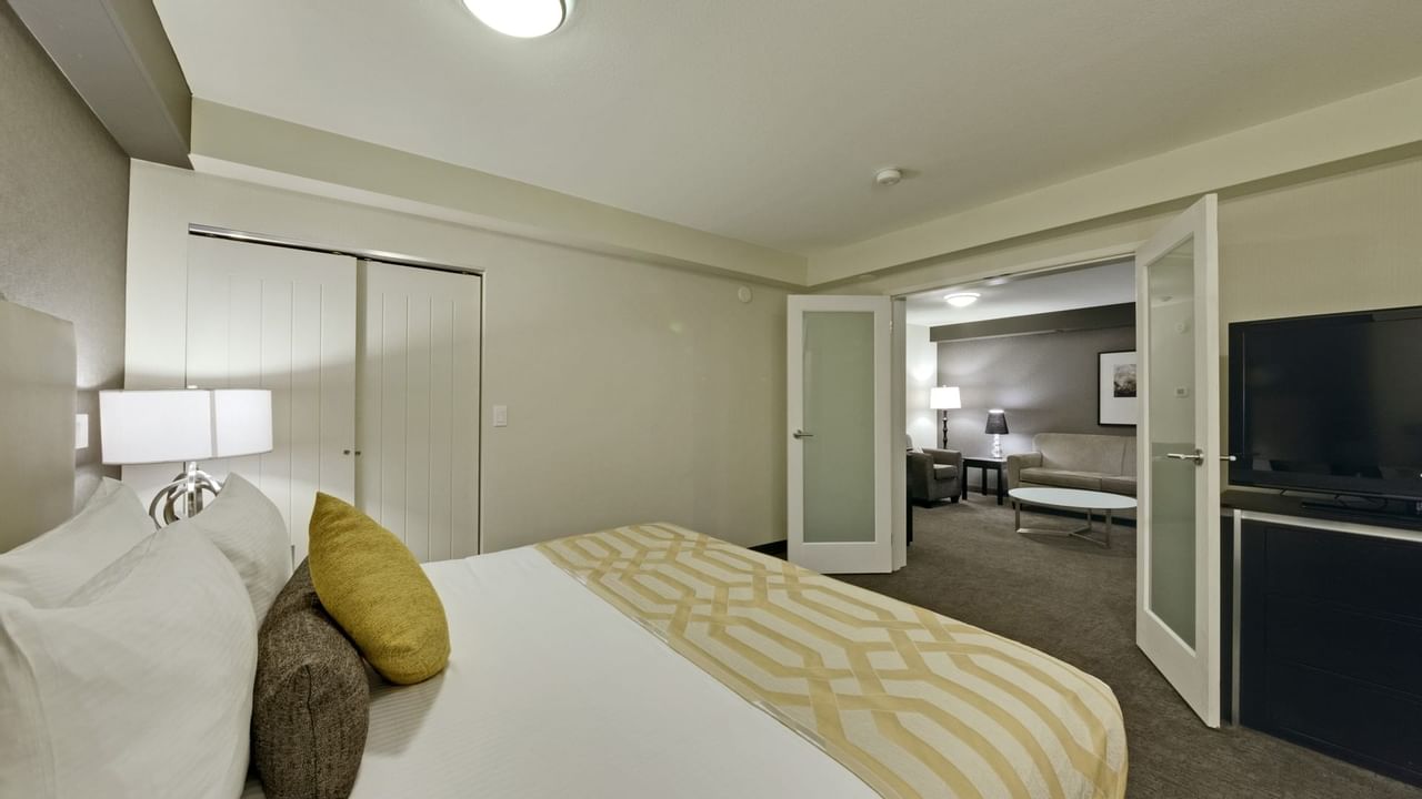 Bed in hotel room facing living area