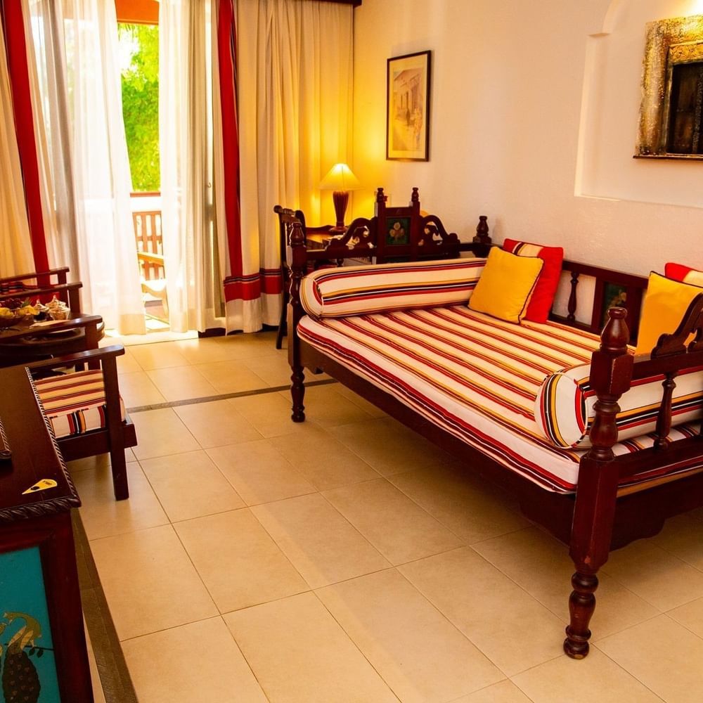 Zanzibar Suite with wooden daybed and balcony at Serena Beach Resort & Spa in Mombasa.
