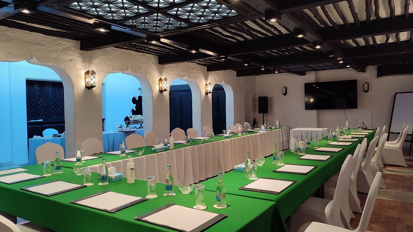 Long green table with white chairs and water bottles at Mashua in Serena Beach Resort & Spa Mombasa.